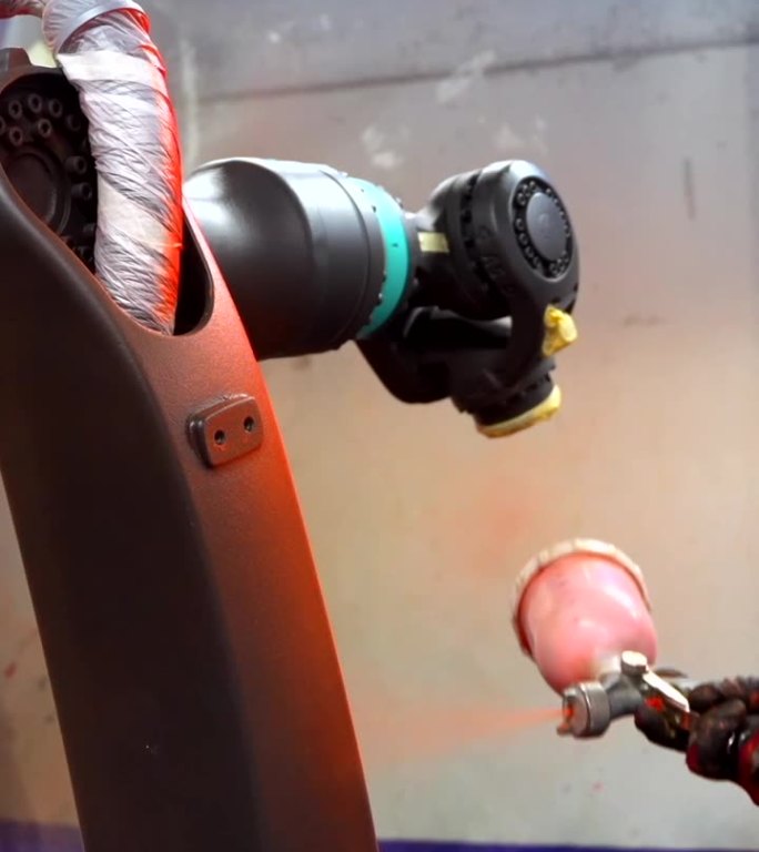 工业画家正在用喷雾剂喷涂机械臂