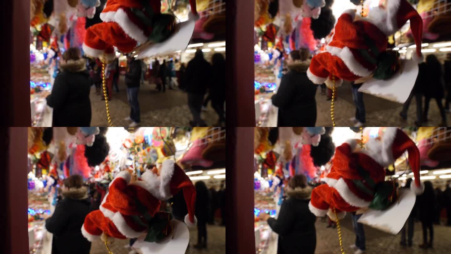 在西班牙马德里的马约尔广场，圣诞老人玩偶在圣诞摊位上上下浮动