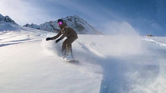 在雄伟的粉雪天，滑雪板运动员在斜坡上滑行