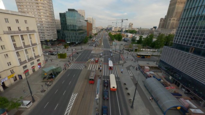 在现代城市华沙，无人机在繁忙的街道上穿行，街道上有汽车和有轨电车。现代摩天大楼