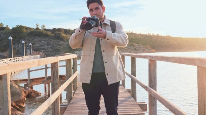 摄影师看着相机在日落的湖面上拍了一张照片