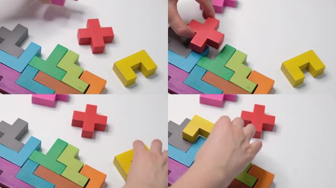 儿童教育理念。特写:慢镜头。手持木块拼图。木材立方体堆叠。复杂的概念和聪明的逻辑思维。