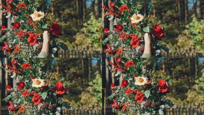 花店装饰设计师用鲜花制作婚礼拱门。特写，一位妇女将一枝黄玫瑰系在插花上。