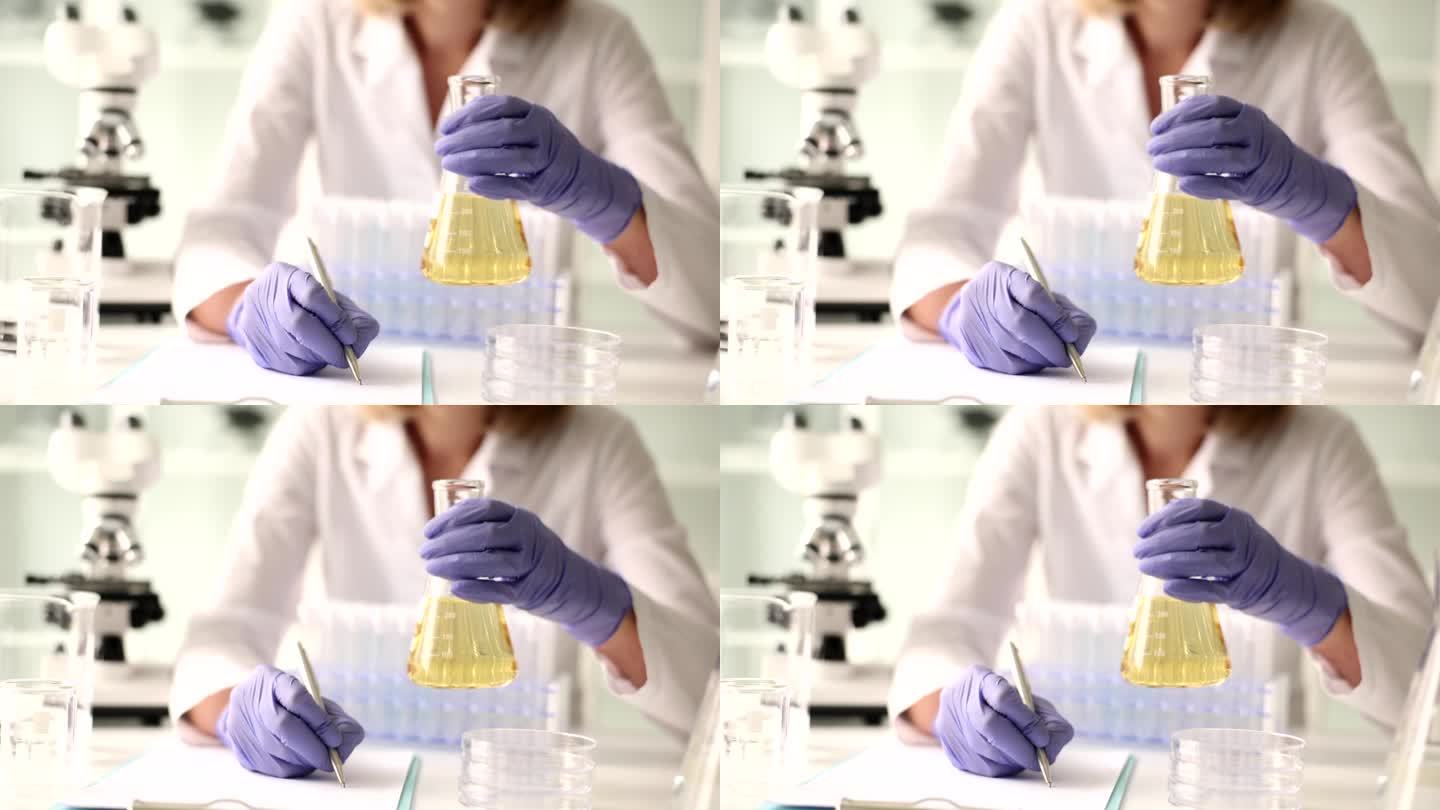 实验室工作人员拿着装有病人书写资料尿液的烧瓶