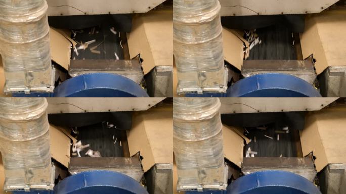 减少浪费。纸屑收起来，废品从纸板箱中产生。机器把纸板刻成纸板箱。纸板箱制造。有声音的镜头。