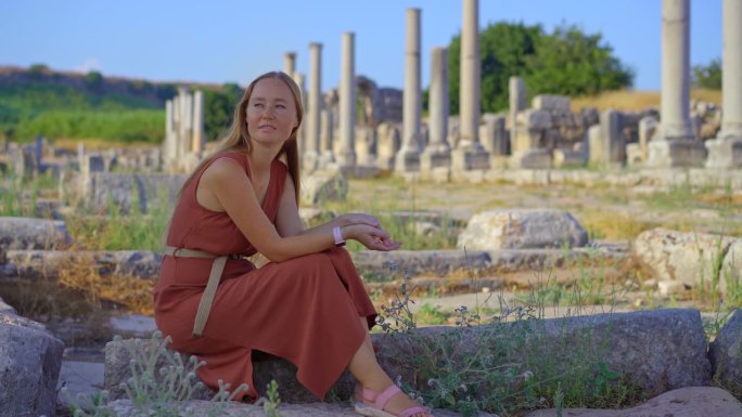一名年轻女子参观位于土耳其安塔利亚的佩尔热古城遗址。这些废墟是这座城市丰富历史的见证，街道、建筑和建