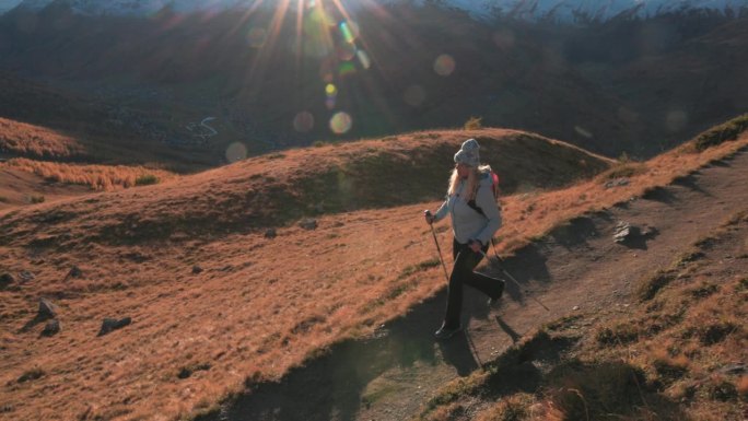 成熟的女性徒步旅行者探索高山山坡，秋天