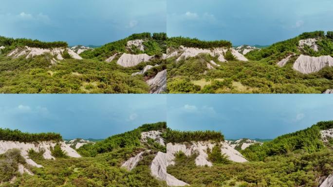 Aerial flyover green vegetated moonscape during cl