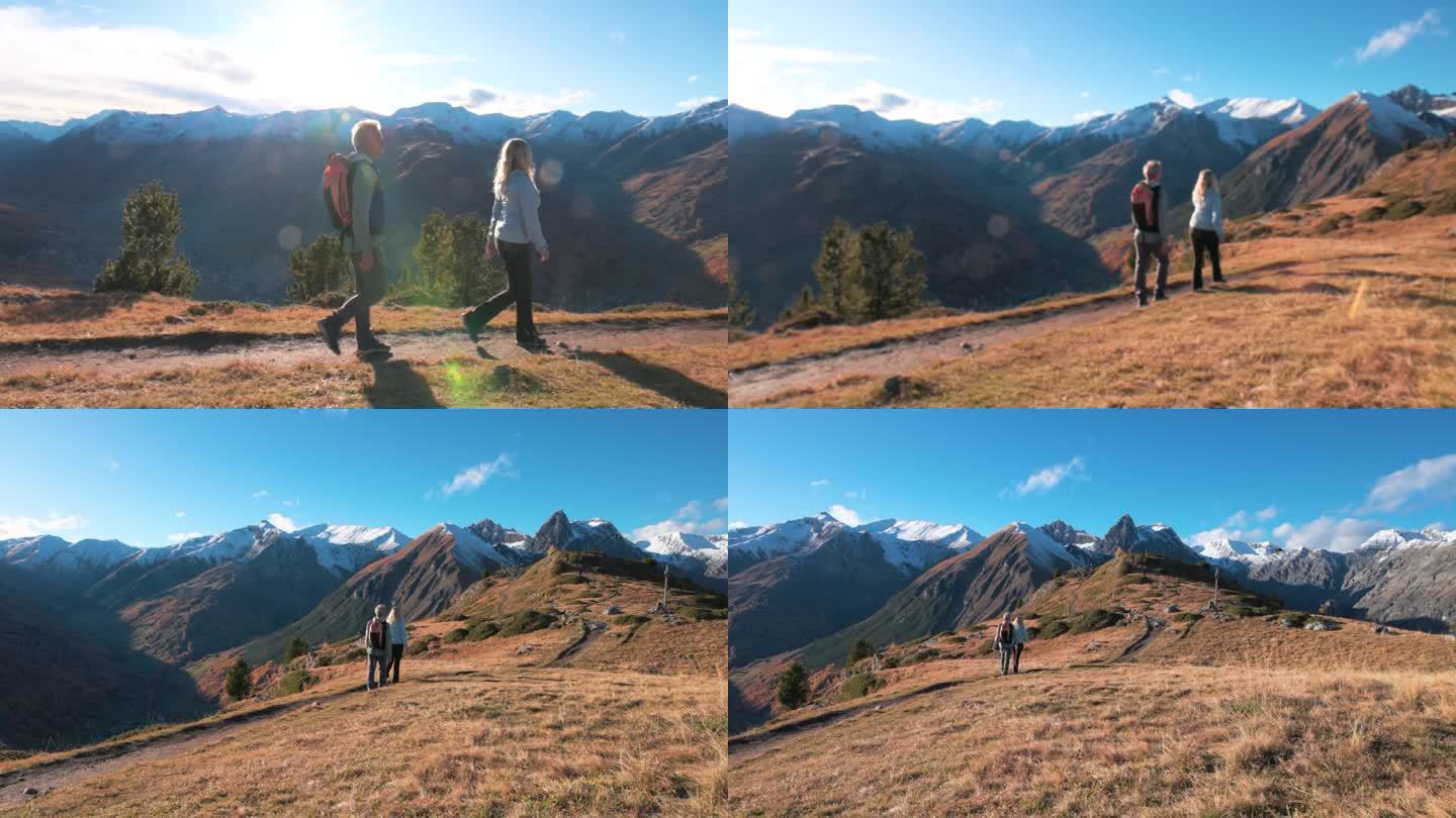 成熟的徒步夫妇穿越高山山腰，秋天