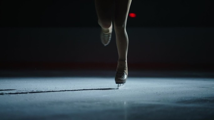 在冰场滑冰的女花样滑冰运动员脚上的冰鞋特写镜头，慢动作镜头