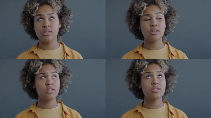 非裔美国妇女在灰色背景下翻白眼的特写慢动作肖像