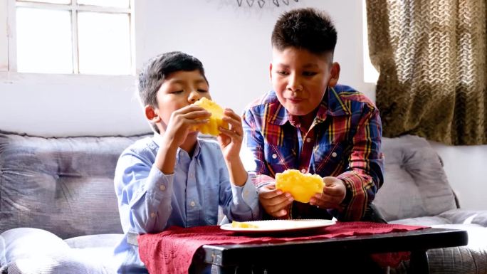 玻利维亚的两个拉丁兄弟在家里吃菠萝