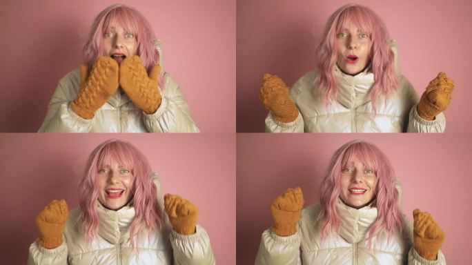 快乐的乐趣美丽的年轻粉红色的头发女人女孩20岁在冬天的大衣在粉红色的背景下在工作室里摆姿势孤立。