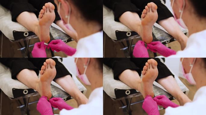 女士在Spa沙龙用钝刀给脚做足疗。腿部和指甲皮肤护理。足疗程序和SPA。特写，选择性对焦。