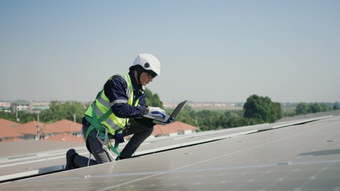 穿制服的工人对太阳能电池板进行有效检查，以最大限度地提高可再生能源的效率。