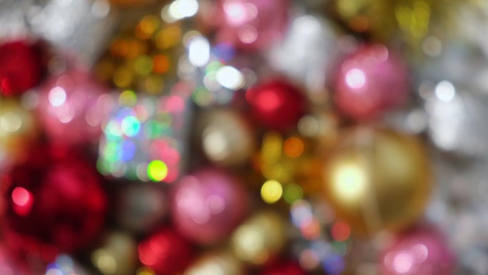 圣诞饰品散焦背景旋转。关闭一个闪闪发光的圣诞树装饰项目转向。新年装饰。许多闪亮的圣诞小玩意，球和灯泡