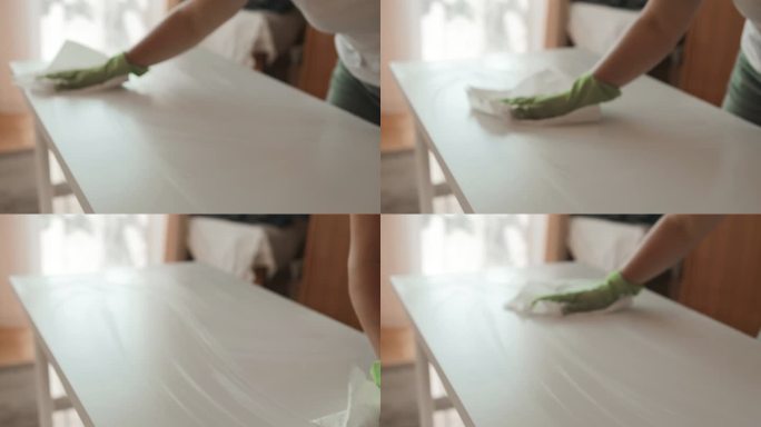 慢镜头中，白人妇女手拿超细纤维布在客厅里清洁和擦拭桌子。在家里做家务的女人。管家的概念。
