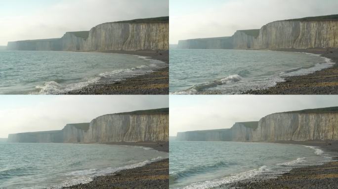 风景如画的白色悬崖耸立在波涛汹涌的大海之上，下面是岩石海滩