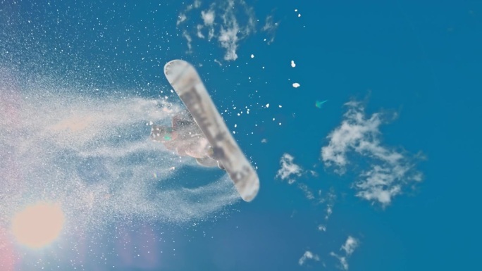 在阳光明媚的日子里，滑雪板运动员的SLO MO对着天空。男子正在雪山上玩单板滑雪。他正在享受假期。