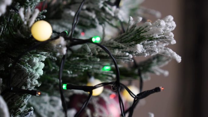 雪花质感的人造圣诞树上闪烁的彩灯串