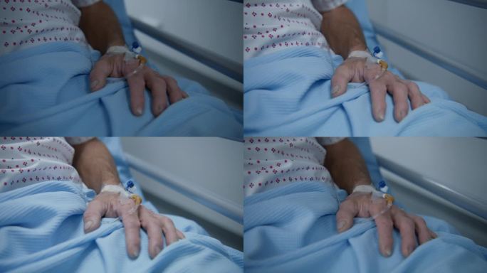 老年病人躺在轮床上，手上有静脉导管