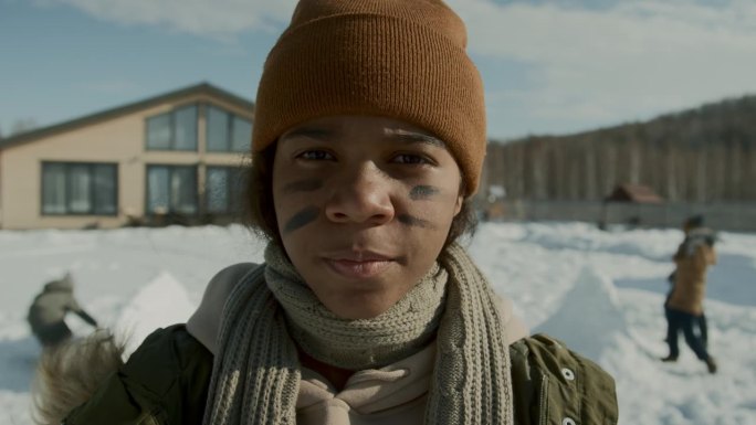 打雪仗前黑人女孩在脸上涂上战争条纹的肖像
