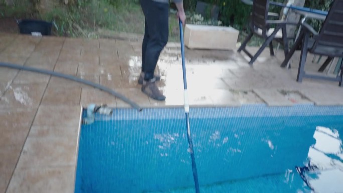 管家丈夫在冬天负责清洁游泳池。维护和消毒概念。