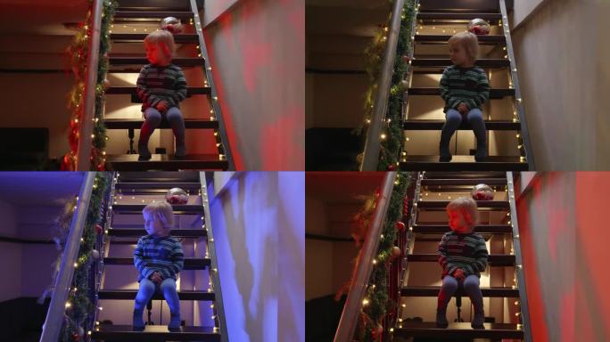 小男孩坐在为圣诞节或新年装饰的楼梯上，看着警灯和警笛。寒假犯罪、盗窃、入室盗窃及防范的概念。