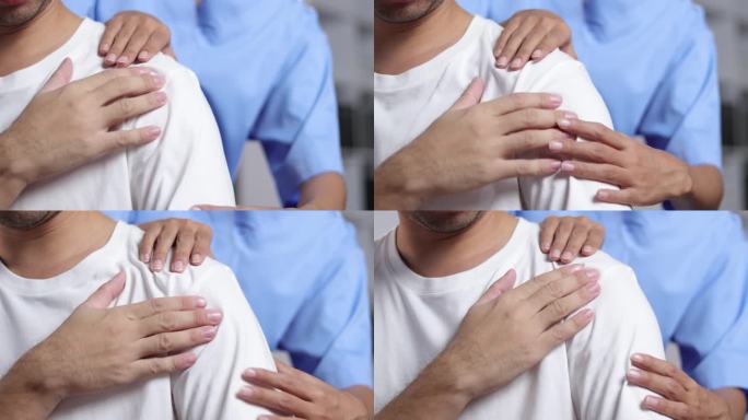 医生在医院的检查室里诊断男子的肩膀疼痛。护士为病人的肩部做按摩和理疗。