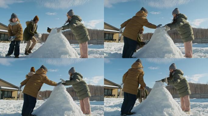 不同的孩子在后院建造雪堡