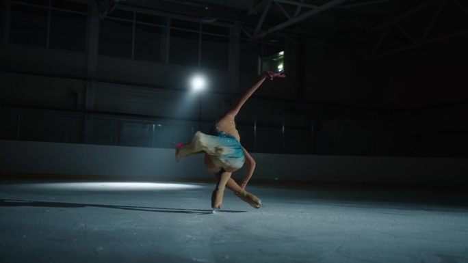 艺术与运动，优雅的年轻女子花样滑冰运动员在溜冰场上旋转，黑暗中的肖像