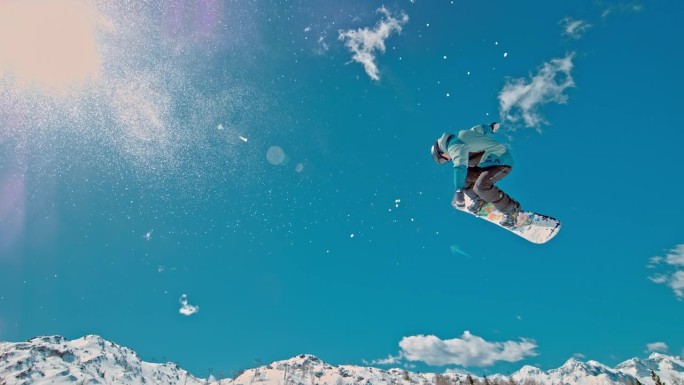 SLO MO -时间扭曲效果/速度斜坡男子滑雪板练习特技在阳光明媚的日子。男子正在山上享受滑雪。他在