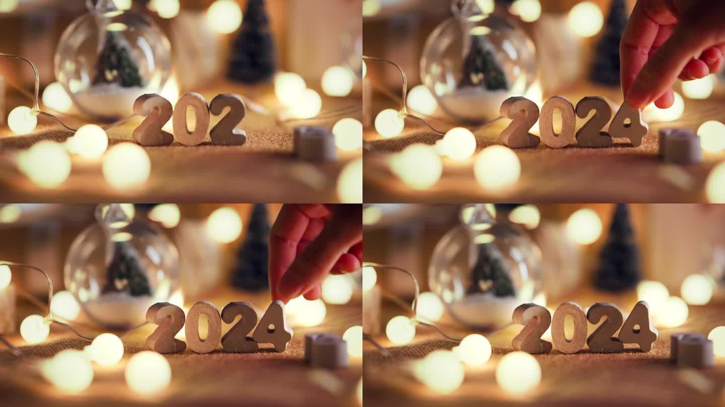 女人的手把2024数字装饰的桌子上，圣诞快乐，新年快乐!