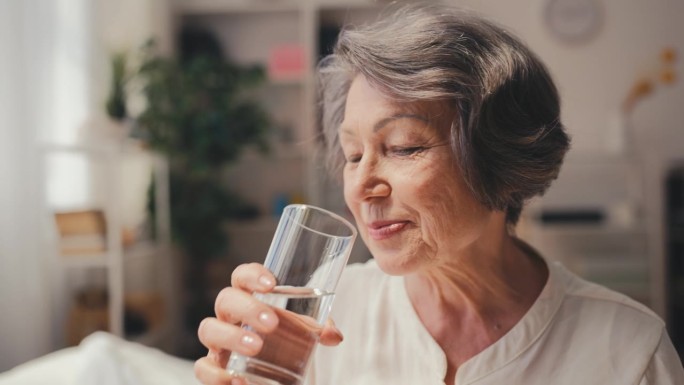 微笑老年妇女用水服药，老年健康支持