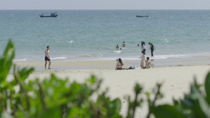 在沙滩上嬉戏的游客海水拍打沙滩