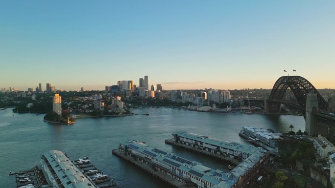 鸟瞰图:日出时间，澳大利亚新南威尔士州悉尼，悉尼港大桥和悉尼港一号码头上空的实时镜头