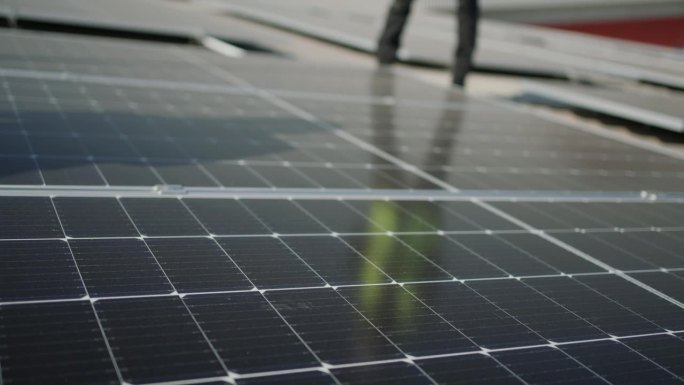 利用太阳能创造更绿色的明天:非洲工人检查可再生能源工厂的光伏板。