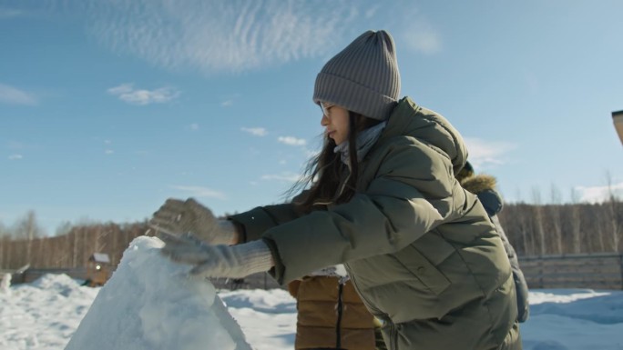 多民族儿童在院子里搭建雪堡