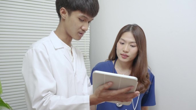 年轻的医生和漂亮的泰国医生或护士一起工作的蓝色制服。