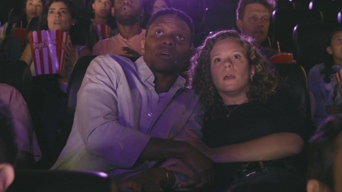 年轻的混血夫妇在电影院观看恐怖的一幕