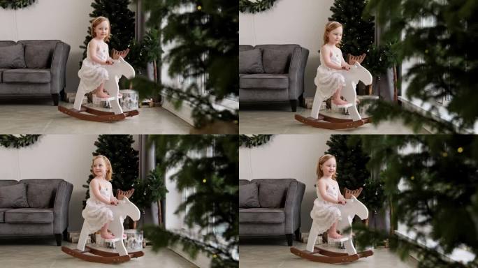 圣诞节早晨，小女孩在摇椅上荡秋千。小孩子摇摆