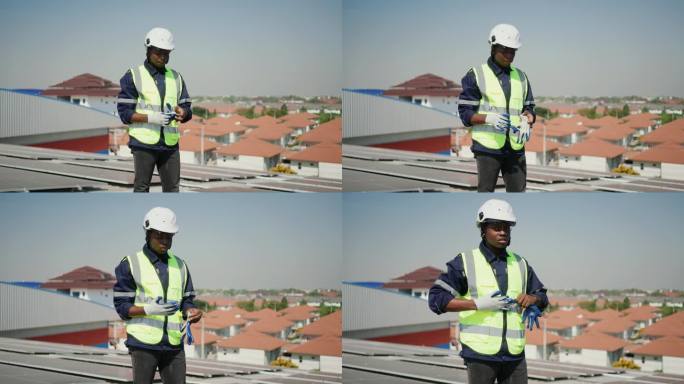 一位非洲男性电力工人在屋顶上利用太阳能的肖像-清洁和绿色能源生产。