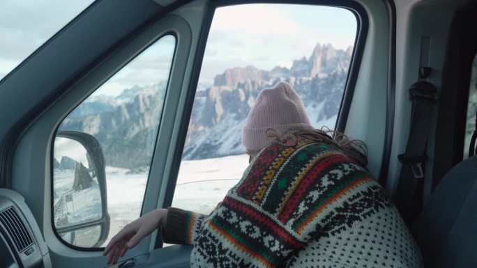 冬天穿着针织毛衣坐在露营车里的女人