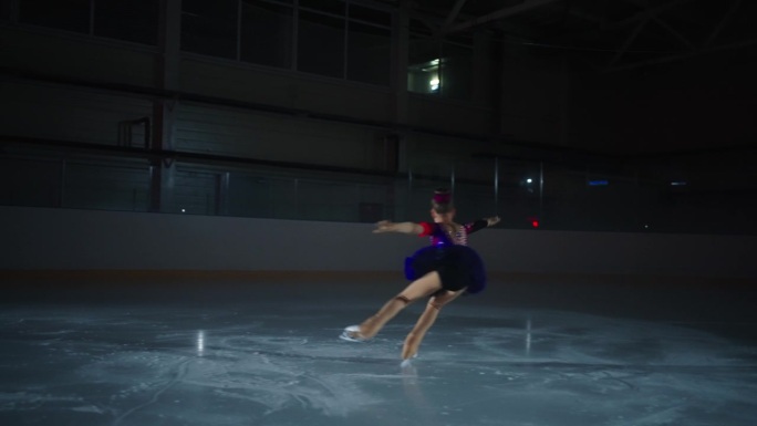 小女孩花样滑冰赛前训练，滑冰运动员在冰场上的剪影