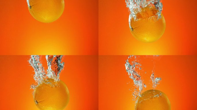 整个橙子落入水中的超级慢动作，孤立在橙色背景上。