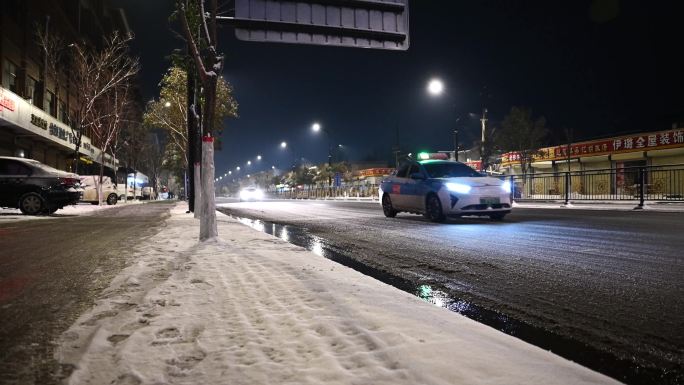 下雪城市道路夜景雪夜车流行人汽车路灯