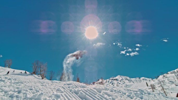 在阳光明媚的日子里，滑雪板运动员的SLO MO对着天空。一个人在白雪皑皑的山上练习。在假期里探索。