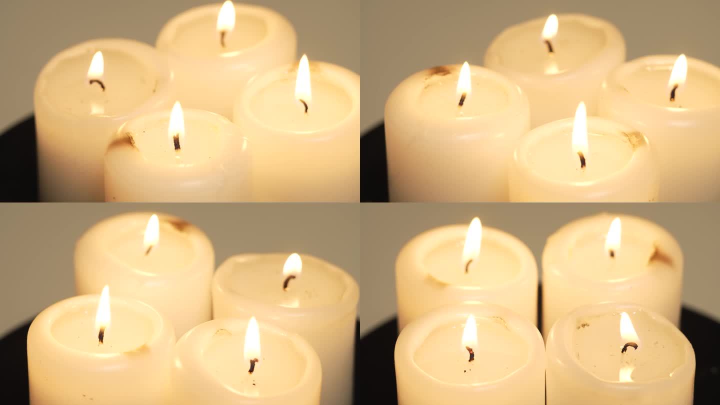 燃烧的四支蜡烛芯火焰近距离旋转在桌子上