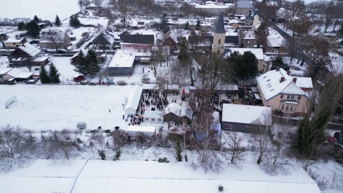 圣诞集市冬雪村，多云的德国。惊人的空中俯视图飞行下降无人机

4 k的片段