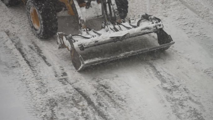 拖拉机在街上铲雪。